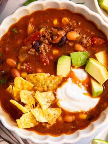 Bowl of taco soup with toppings.