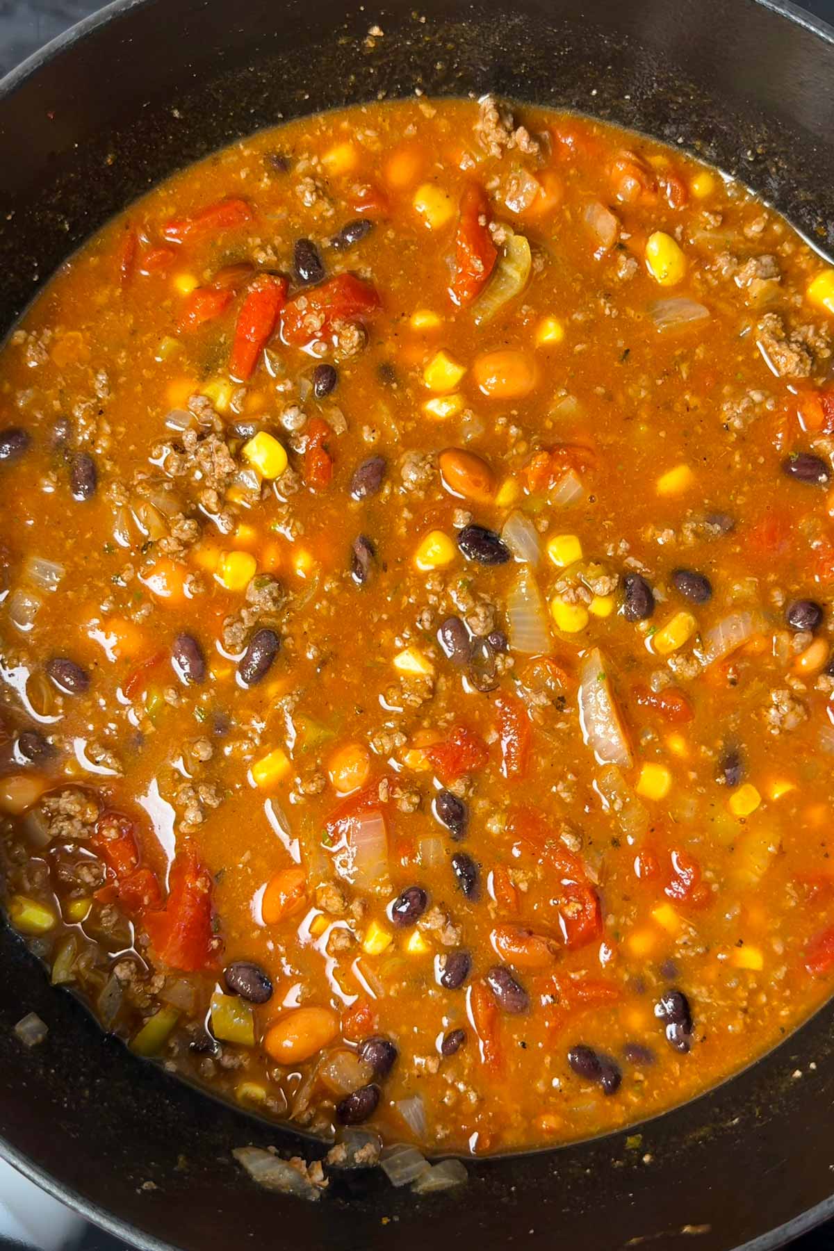 Uncooked taco soup in cast iron pot.
