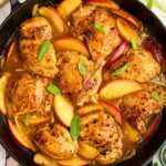 Overhead view of apple chicken in a cast iron skillet.