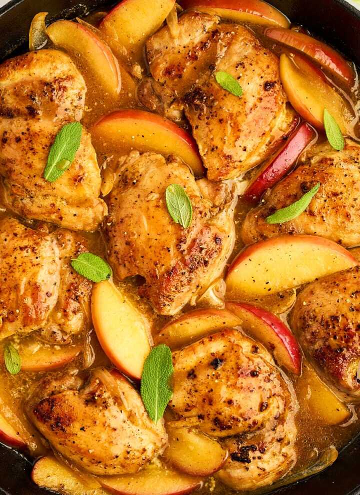 Overhead view of apple chicken in a cast iron skillet.