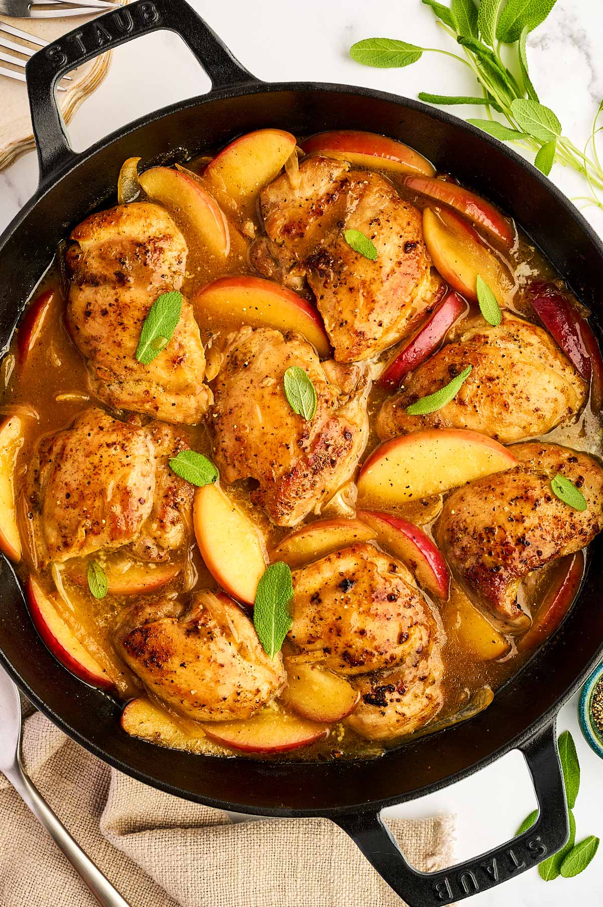Overhead view of apple chicken in a cast iron skillet.