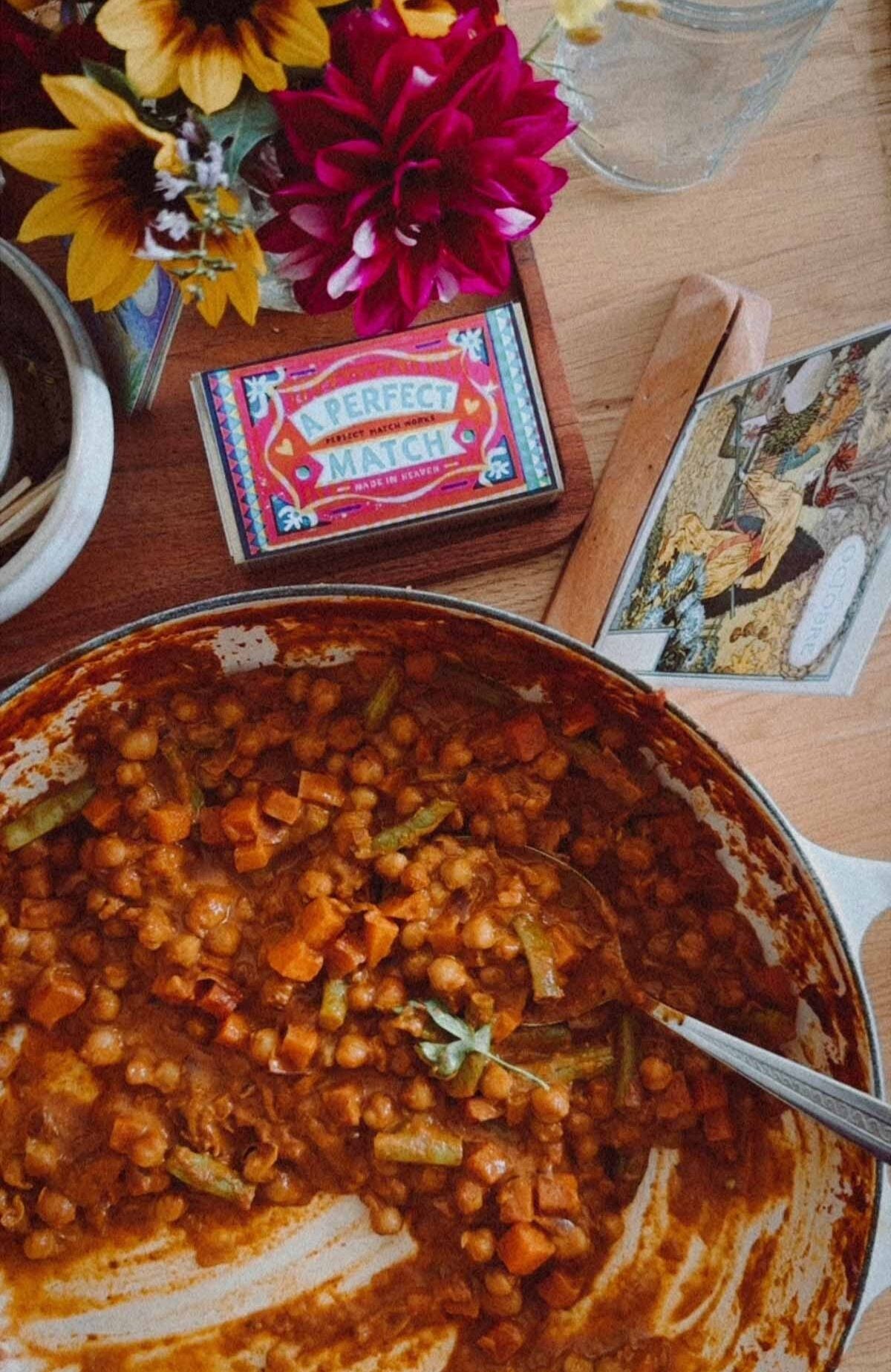 Dinner table with decorations and a pan of chickpea curry.