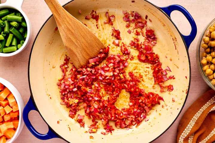 Sautéing red onion in a braiser.